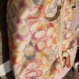 Large Coach Handbag with Rainbow colors on a Beige Background
